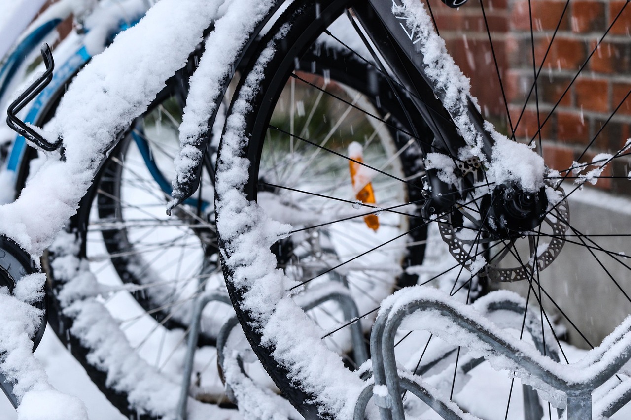 Fahrräder im Schnee, Nahaufnahme von verschneiten Reifen in einem Fahrradständer.