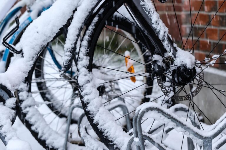Fahrräder im Schnee, Nahaufnahme von verschneiten Reifen in einem Fahrradständer.